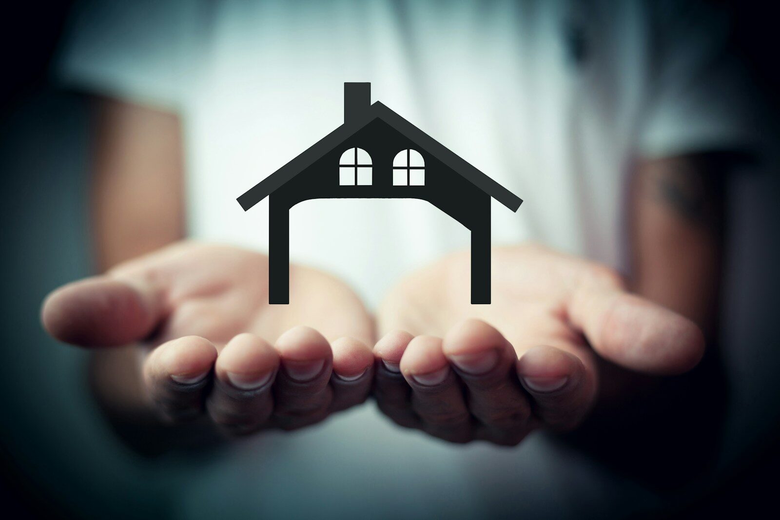 Hands holding a silhouette of a house